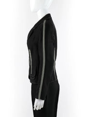A black one-shoulder dress with a prominent silver zipper running down the front and a white bow detail at the hem, displayed on a white mannequin against a white background.