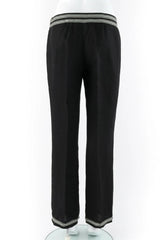 Black wide-leg trousers with contrasting striped trim at the elastic waistband and the bottom hems, displayed on a white mannequin against a white background.