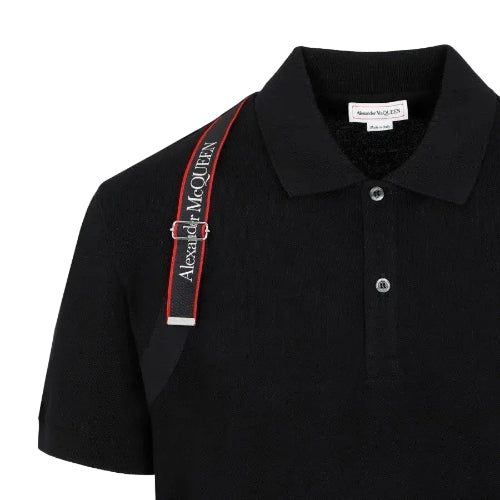 Black polo shirt with a red and white striped shoulder strap on a black background