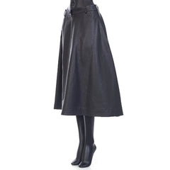 Black leather skirt worn by a person on a white background