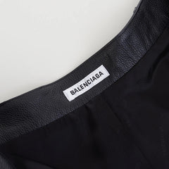 Close-up of a Balenciaga label on a black garment.