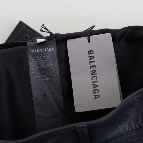 Black Balenciaga shoes with tags on a light gray background