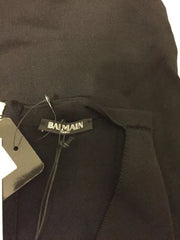 Close-up of a black garment with a brand label on a dark background