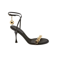 Black high-heeled shoe with gold accents on a white background