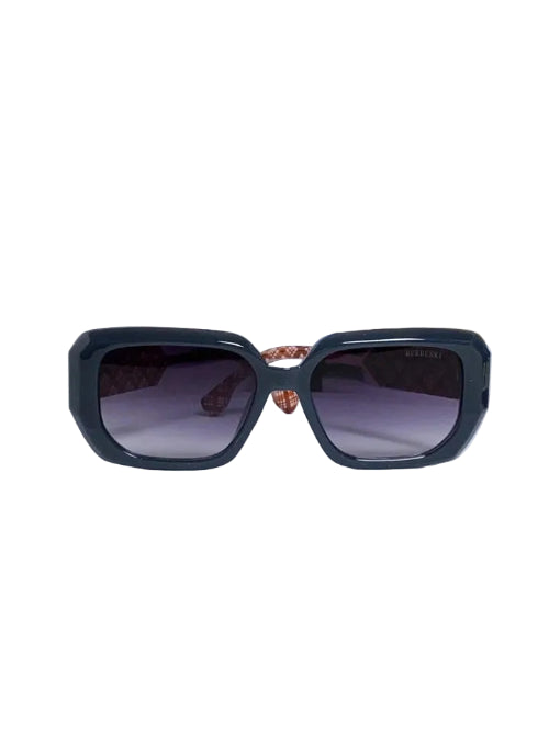 Black square sunglasses with dark lenses, displayed on a white pedestal with a blue patterned box in the background.