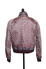 A long-sleeve patterned jacket displayed on a black dress form mannequin against a plain white wall. The jacket features a geometric diamond pattern in dusty pink, white, and dark purple, with a solid dark purple ribbed hem and cuffs.