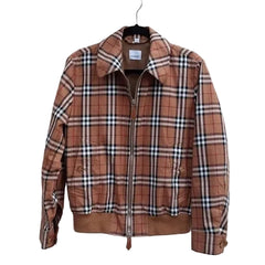 A brown and beige plaid zip-up jacket hanging on a black hanger against a white horizontal-slat wall.