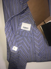 A Burberry men's long-sleeve button-up shirt with a blue, white, and gray chevron pattern, shown with its white brand label and brown packaging tags.