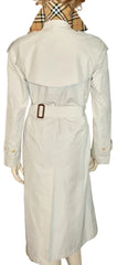 A light beige trench coat displayed on a mannequin, viewed from the back. The coat features a matching waist belt with a brown buckle.