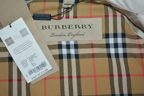 Burberry plaid garment interior with a visible Burberry London England label and a white product tag attached, showing the classic beige, navy, black, white, and red check pattern.