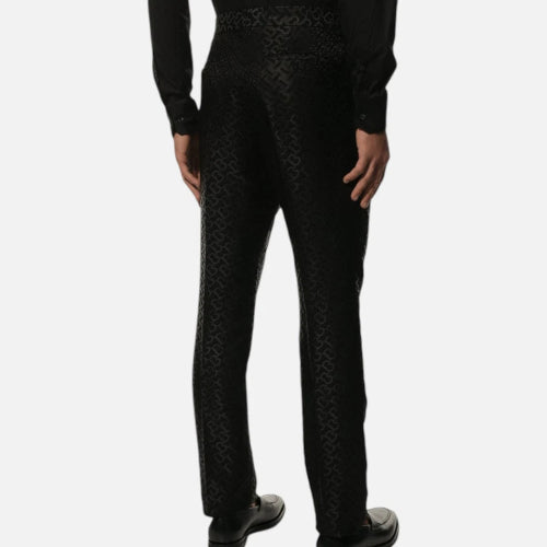 A person wearing black slim-fit trousers, shown from the waist down against a plain white background.