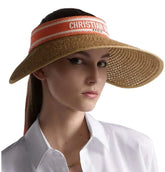 Woman wearing a straw visor with 'Christian Dior' branding on a white background