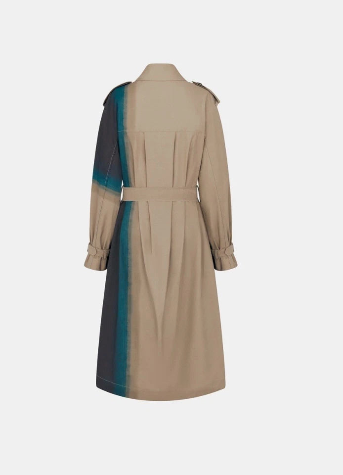 A beige trench coat shown from the back, featuring a vertical color-blocked stripe in dark gray and teal-blue along the left side, against a light gray background.