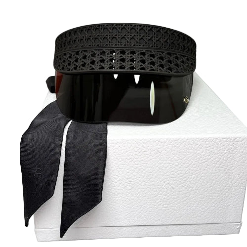 A black perforated leather belt with a matching black ribbon, presented on a white box.