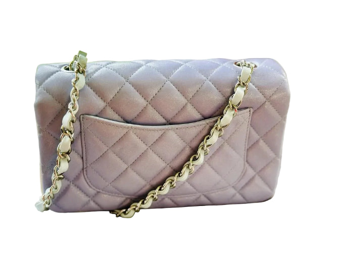 Quilted handbag with gold chain strap on a light surface
