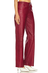 Red leather pants worn by a person on a white background