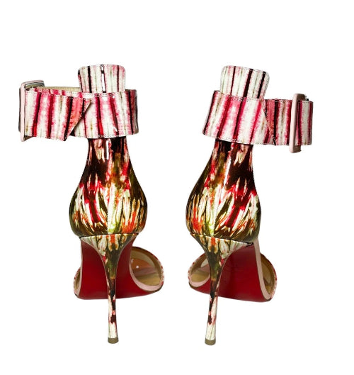 Pair of high-heeled shoes with colorful design and striped ribbon on a white background