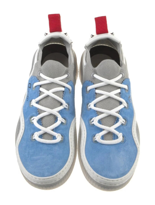 A pair of light blue canvas sneakers with white laces and red accents on the tongue and heel, shown against a plain white background.