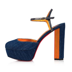 Blue denim high-heeled shoe with orange interior on a white background