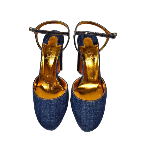 Pair of blue denim high-heeled shoes with gold insole on a white background