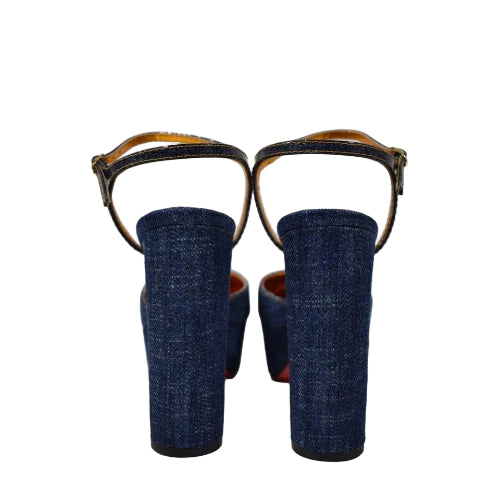 Pair of blue denim shoes with brown straps on a white background