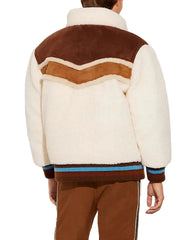 Person wearing a brown and white jacket with a chevron pattern on a white background