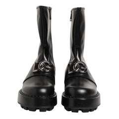A pair of black leather ankle boots with chunky lug soles and side zippers, shown against a plain white background.