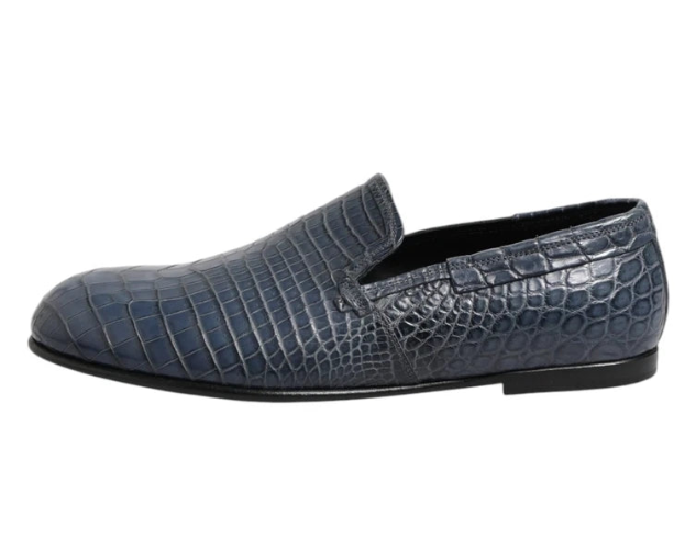 Blue crocodile-textured loafer shoe on a white background