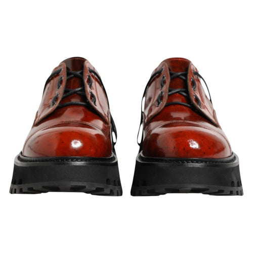 Pair of red leather shoes with black soles on a white background