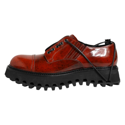 Red leather shoe with black sole on a white background