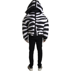 Person wearing a black and white zebra-striped hoodie on a white background