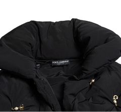 Black puffer jacket with Dolce & Gabbana label on a white background