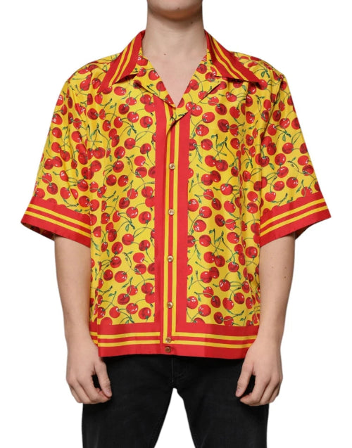 Person wearing a vibrant yellow shirt with red cherry pattern on a white background