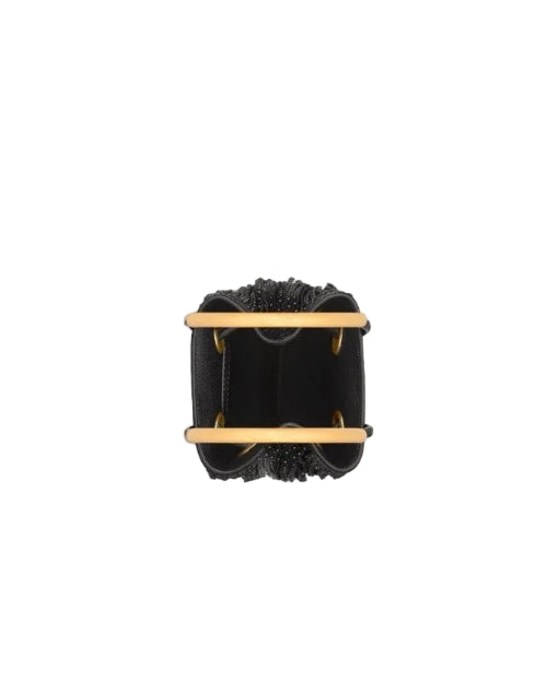 A black leather cuff bracelet with a wide, structured rectangular design, featuring two horizontal gold-tone metal bars and a textured beaded top edge, shown from a top-down view on a light gray background.