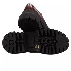 Black boots with a brand logo on the sole against a white background