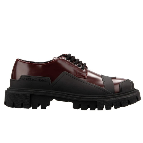 Brown leather shoe with black sole on a white background