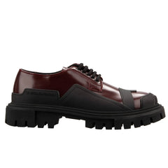 Brown leather shoe with black sole on a white background