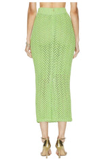 Green crochet skirt worn by a person on a white background
