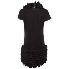 Black dress with ruffled details on a plain background