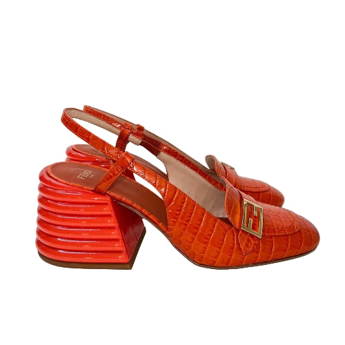 Orange high-heeled shoes with a gold buckle on a white background