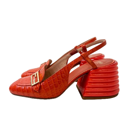 Red high-heeled shoes with a crocodile texture on a white background