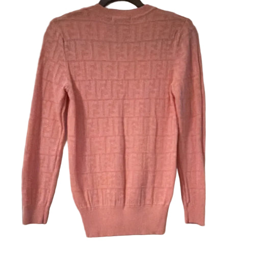 Pink sweater hanging on a door