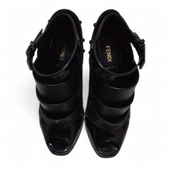 Black strappy high-heeled shoes on a white background