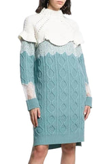 Teal cable knit dress with white lace details on a plain background