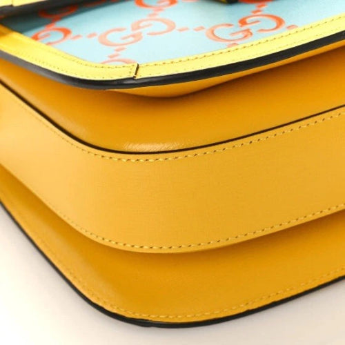 Close-up of a yellow handbag with a light blue interior featuring orange text.