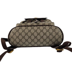 Designer handbag with patterned fabric and brown straps on a white background