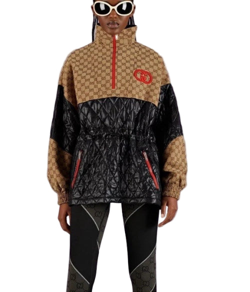 Person wearing a black and beige patterned jacket with a red logo on a purple background