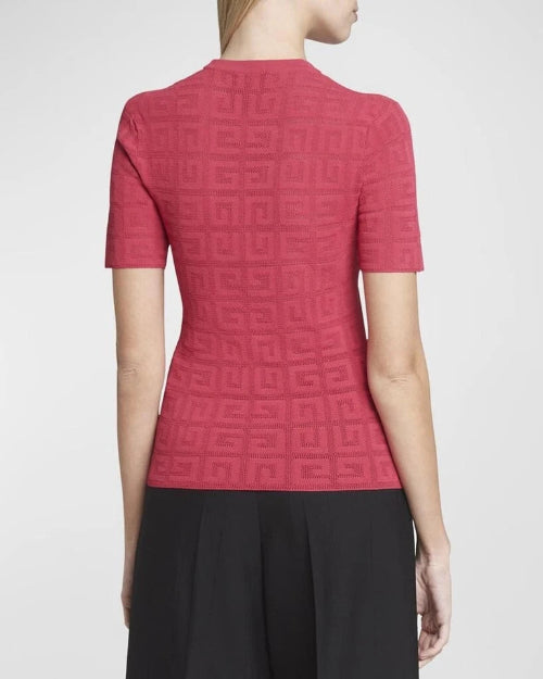 Red patterned top worn by a person on a white background
