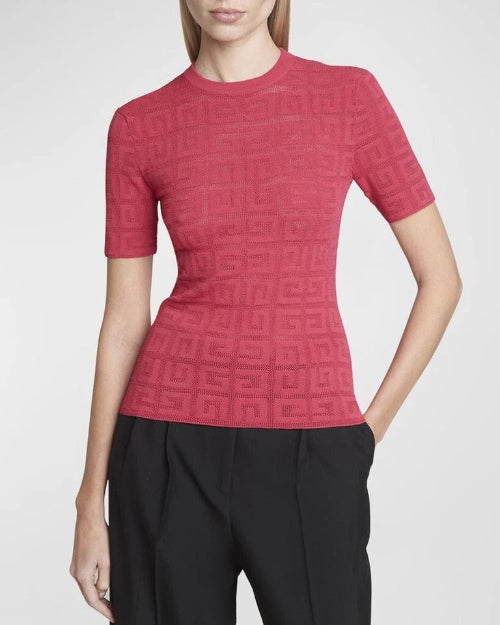 Woman wearing a red knit top with black pants against a neutral background