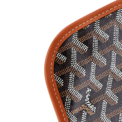 Close-up of a Goyard monogram canvas bag corner with brown leather trim and white stitching on a white background.